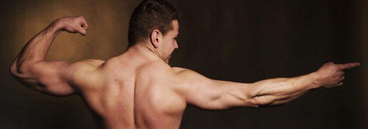 Kuvassa lihaksikas mies esittelee selkälihaksiaan.