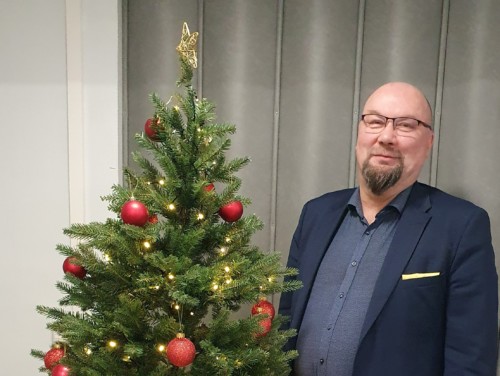 Blogin kirjoittaja Matti Isokallio seisoo joulukuusen vieressä.
