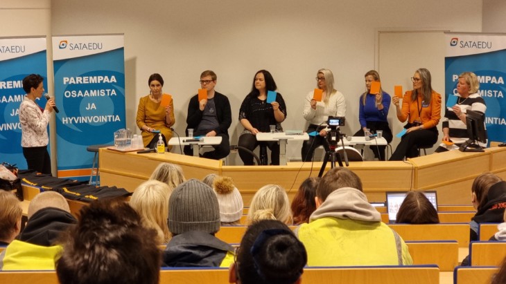 Tilaisuuden juontaja Mari Ahvenjärvi esittää kysymyksen, johon panelistit  Eeva Kalli, Pyry Väre, Maria Metsomäki, Henrika Palenius, Niina Immonen,  Minna Nurmi ja Leena Jokinen-Anttila vastaavat lappuäänestyksellä. 