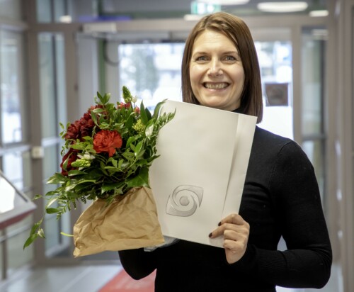 Työllistymisen edistäjä -palkinnolla palkittu Laura Poikkeus palkintokukkien ja kunniakirjan kanssa.