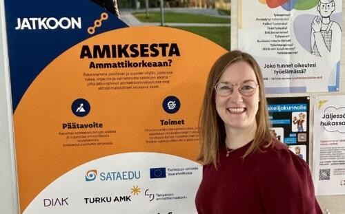 Noora Elonen seisoo JATKOON-julisteen vieressä.